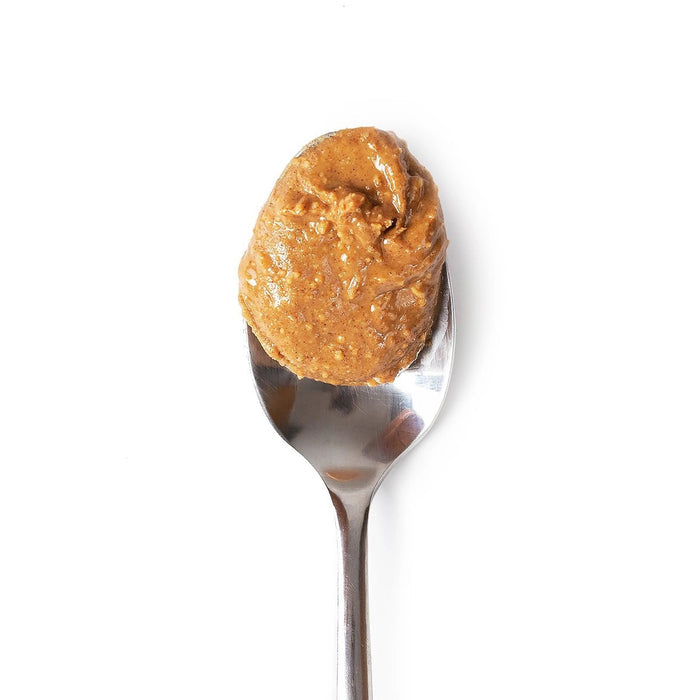 A metal spoon holds BIG SPOON ROASTERS - WAG BUTTER PUMPKIN SPICE against a plain white background—an excellent healthy dog treat from BIG SPOON ROASTERS.
