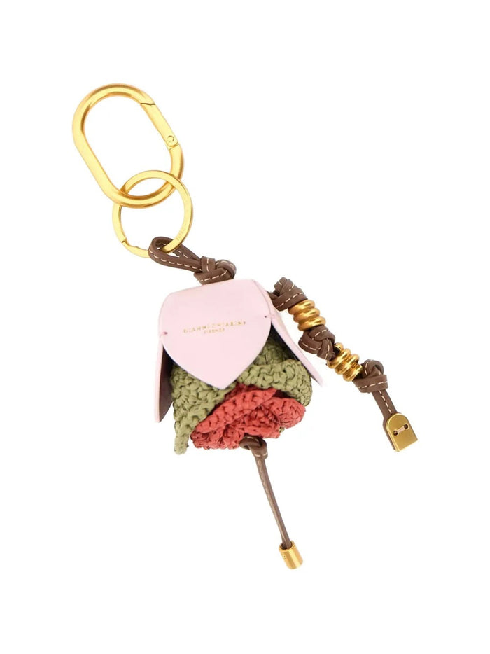 The GIANNI CHIARINI STRAW FLOWER KEY RING / BAG CHARM features a rosebud-shaped charm with pink, green, and red details, woven straw inserts, a brown stem with gold accents, and a small padlock.