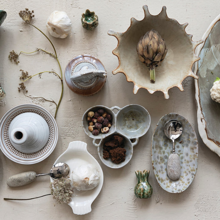 The CREATIVE COOP STONEWARE DISH features an oval ceramic design with a white base and yellow-green speckles from a reactive glaze. Shown top and side, these unique pieces add handcrafted charm to your kitchen decor.