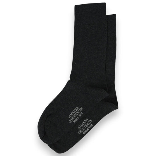 A pair of anthracite melange mid-calf socks from AMANDA CHRISTENSEN, crafted in a luxurious cotton and cashmere blend with white text on the soles, arranged on a white background—these NOBLE socks showcase timeless style and meticulous attention to detail.