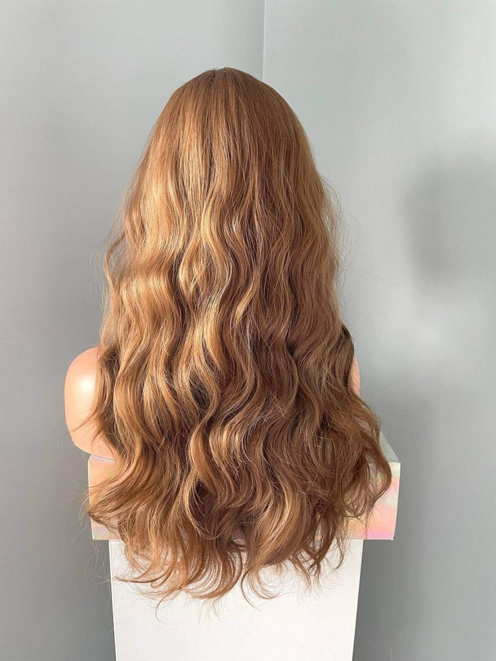 Long brown curly wig with fringe showcasing flowing curls and rich chocolate brown tones from the back view.