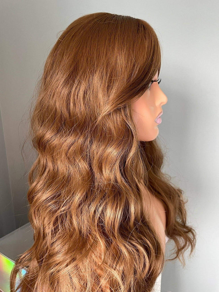Mannequin head with long, wavy, brown hair on a plain background