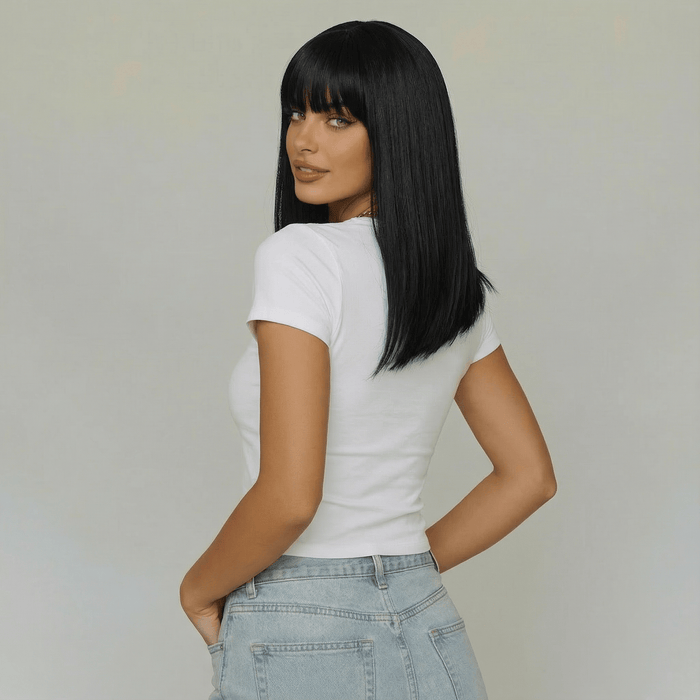 Cecil short black wig with bangs worn by a model showing a sleek bob haircut from the back.
