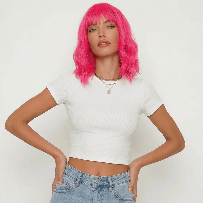 Model wearing a Cerise neon pink wig with bangs, showcasing vibrant color and stylish outfit.
