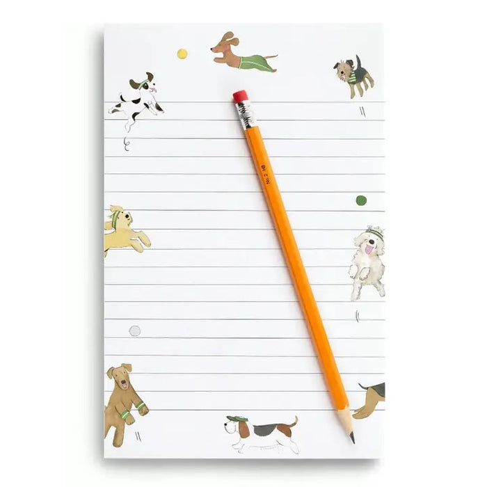 E. FRANCES PAPER's NOTEPAD OFF LEASH features lined pages with playful dog and ball illustrations along the edges, making it a perfect stationery gift for dog lovers or pet parents—ample space provided for your notes.