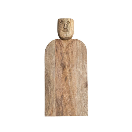 The CREATIVE COOP HAND-CARVED MANGO WOOD CHARCUTERIE/CUTTING BOARD WITH FACE HANDLE features a flat, rectangular shape, rounded edges, and rustic grain patterns for a handcrafted look.