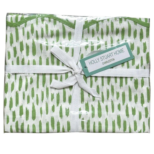 The HOLLY STUART DESIGNS Mahjong and Game Tablecloth in Dash Green Tea features a folded white cotton cloth with a green brushstroke pattern, tied with a white ribbon—perfect for elevating any game or mahjong table.