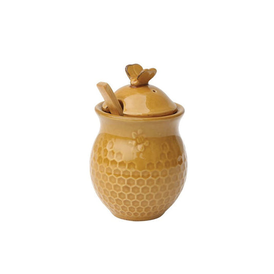 The CREATIVE COOP HONEYCOMB HONEY JAR AND BEE LID features a ceramic jar with a honeycomb pattern, bee-shaped handle, and wood honey dipper, all in warm golden tones on a white background.