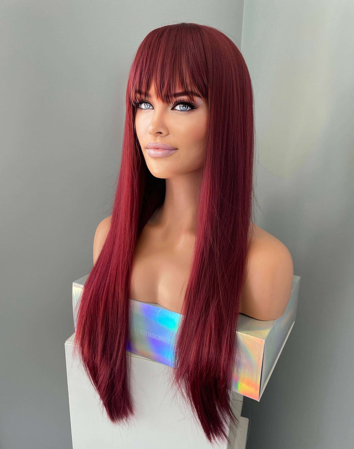 long wine red silky straight wig with bangs displayed on a mannequin, showcasing its sleek and vibrant appearance.
