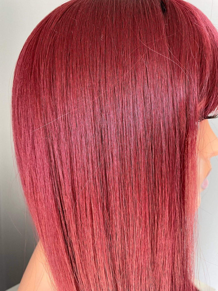 Close-up of the Raven long wine red silky straight wig with bangs, showcasing its sleek, glossy strands.