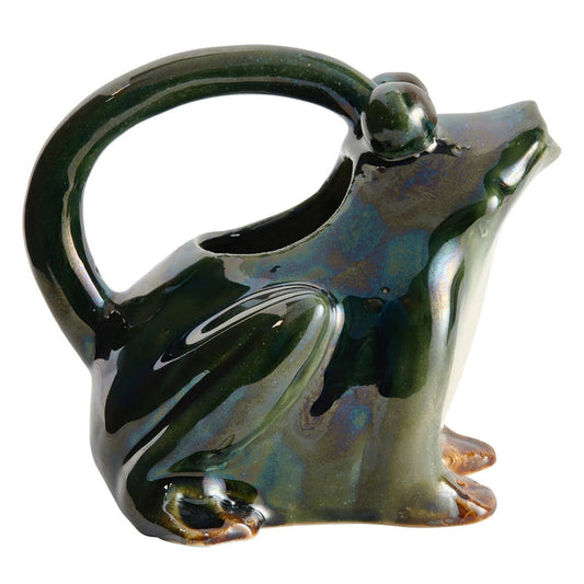 The CREATIVE COOP STONEWARE FROG WATERING PITCHER features a glossy dark green frog shape with brown-accented feet, an arched handle over its back, and a spout at the mouth—ideal as a decorative plant pitcher.