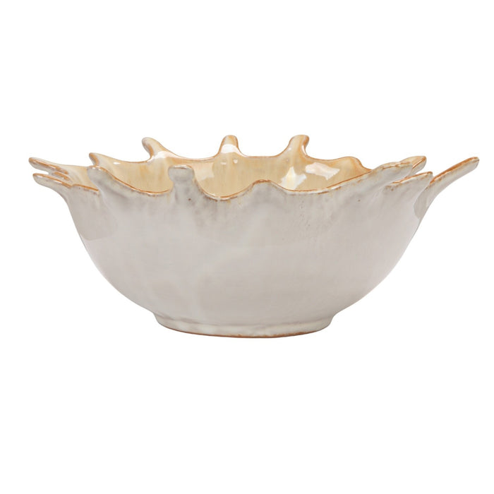 A close-up of the CREATIVE COOP STONEWARE SUNBURST BOWL, a beige ceramic piece with a glossy finish and brown-tinted edges, featuring handcrafted textured details and pointed tips inspired by a leaf’s natural form.