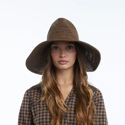 The WYETH Lina Raffia Sun Hat in Chocolate features a packable, ultra wide brim and slightly pointed crown, shown against a plain white background.